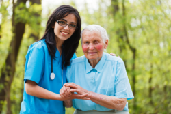 caregiver supporting an elderly woman