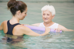 elderly woman in pool with her caregiver